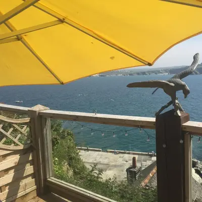 a yellow umbrella and a bird statue on a balcony at Seaside Apartment in Newquay