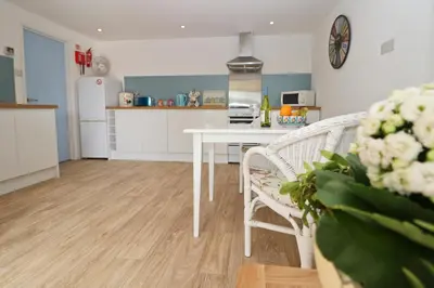 a kitchen with a table and chairs in a room at Seaside Apartment in Newquay