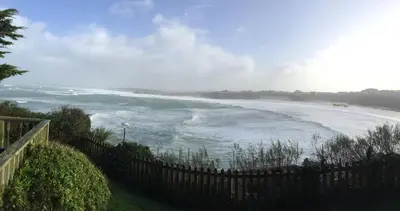 a view of a beach with a fence and the ocean at Seaside Apartment in Newquay