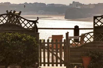 a wooden fence with a view of a beach at Seaside Apartment in Newquay