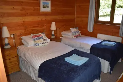 a bedroom with two beds in a log cabin at East Crinnis Log Cabin in Par