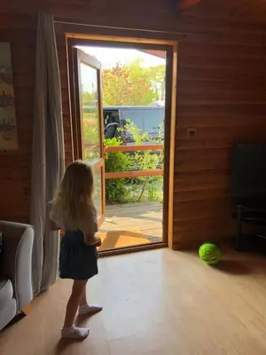 a little girl standing in front of a door at East Crinnis Log Cabin in Par