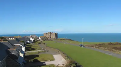 a row of houses with the ocean in the background at Bosayne Guest House in Tintagel