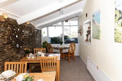 a dining room with a table and chairs at Bosayne Guest House in Tintagel