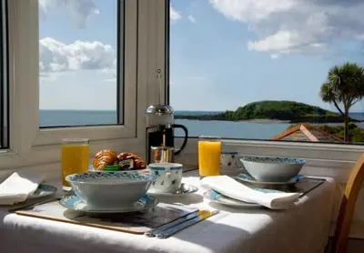 a table with plates of food and a view of the ocean at Seaview in Looe