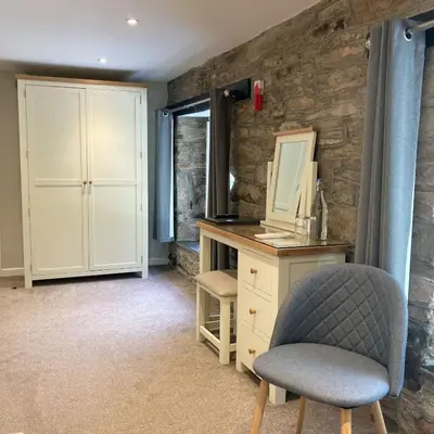 a bedroom with a desk and a chair and a mirror at The Britannia Inn and Restaurant in Par
