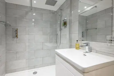 a white bathroom with a sink and a shower at The Britannia Inn and Restaurant in Par