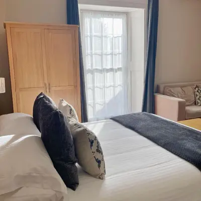 a bedroom with a bed with pillows and a window at The Britannia Inn and Restaurant in Par