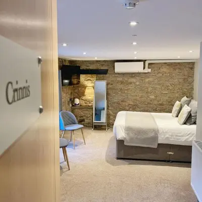 a hotel room with a bed and a chair at The Britannia Inn and Restaurant in Par