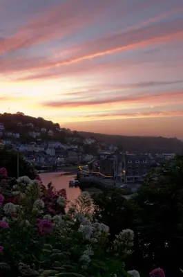 a view of a river at sunset with a city at The Watermark in Looe