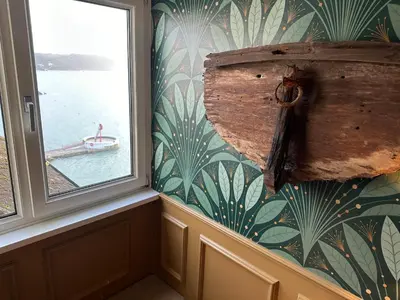 a window in a room with a boat in the water at The Watermark in Looe