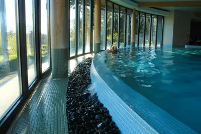 a swimming pool with a person in the water at The Cornwall Hotel Spa & Lodges in St Austell