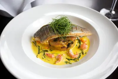 a plate of food with a fish dish with shrimp at The Cornwall Hotel Spa & Lodges in St Austell
