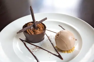 a chocolate dessert on a plate with a scoop of ice cream at The Cornwall Hotel Spa & Lodges in St Austell