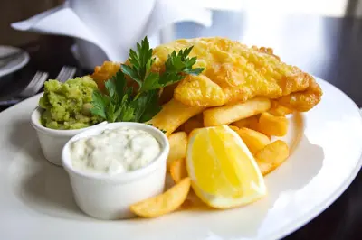 a plate of food with fish and chips and dip at The Cornwall Hotel Spa & Lodges in St Austell