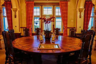 a dining room with a wooden table and chairs at Camelot Castle Hotel in Tintagel