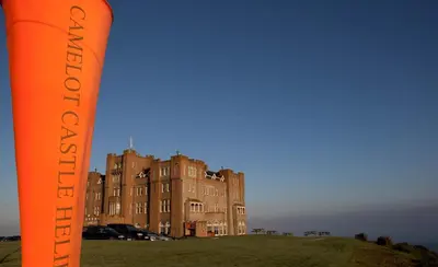 an orange sign in front of a building at Camelot Castle Hotel in Tintagel