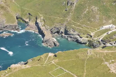 an aerial view of a body of water next to a mountain at Camelot Castle Hotel in Tintagel