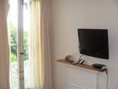 a flat screen tv on a wall next to a window at Trelawney Guest House Room only in Falmouth