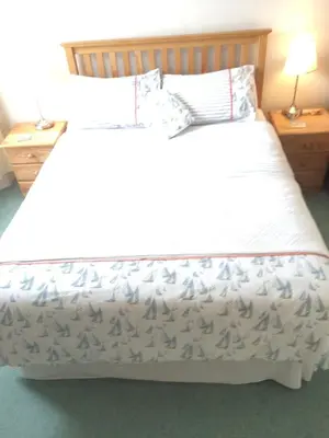 a bedroom with a white bed with two night stands at Trelawney Guest House Room only in Falmouth