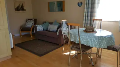 a living room with a table and a couch at Chalets & Lodges at Atlantic Bays Holiday Park in Padstow