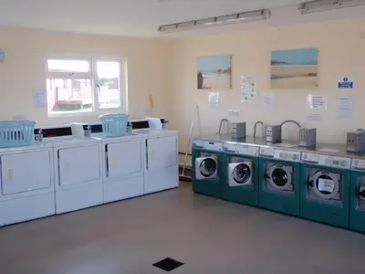 a laundry room with four washing machines in it at Chalets & Lodges at Atlantic Bays Holiday Park in Padstow