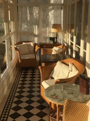 a living room with chairs and a table and windows at Dolphin Guest House in Looe