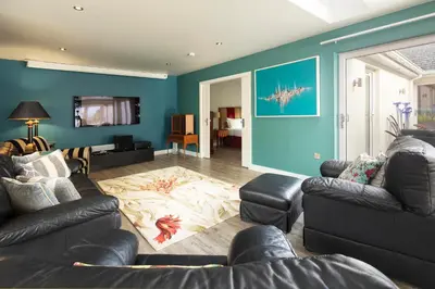a living room with two couches and a blue wall at Talland Bay Hotel, Looe in Talland