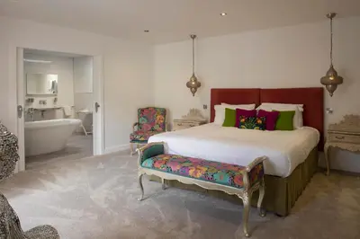 a bedroom with a large bed and a bath tub at Talland Bay Hotel, Looe in Talland