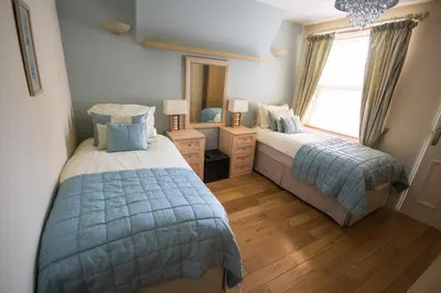 a bedroom with two beds and a large window at Atlantic Heights Guest House in St Ives
