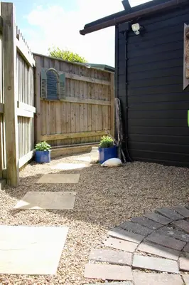 a backyard with two potted plants next to a fence at Fistral Studio in Newquay