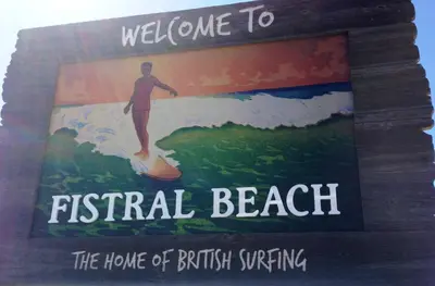 a book with a man on a surfboard on a wave at Fistral Studio in Newquay