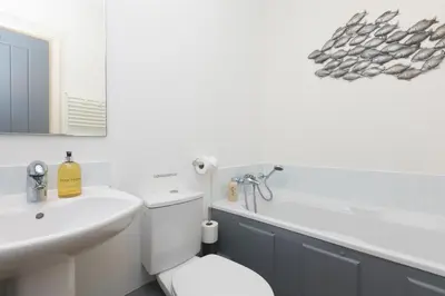 a bathroom with a toilet and a sink and a tub at Oystercatcher in St Ives