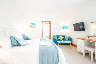 a bedroom with a bed and a blue couch at Padstow Bed & Breakfast in Padstow