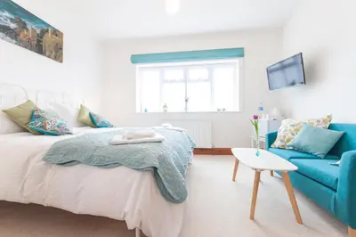 a bedroom with a bed and a blue couch at Padstow Bed & Breakfast in Padstow