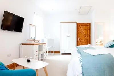 a bedroom with a bed and a table and a tv at Padstow Bed & Breakfast in Padstow