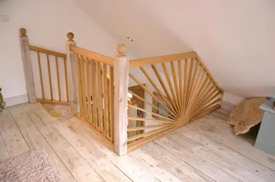 a wooden spiral staircase in a room with wooden floors at Neptunes Rest in St Austell