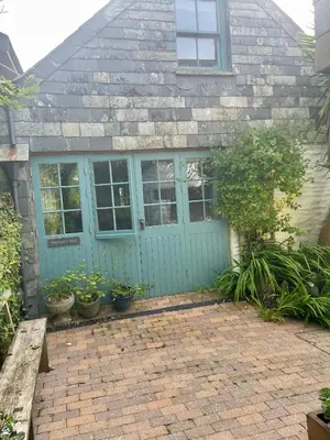 a house with a blue door and some plants at Neptunes Rest in St Austell