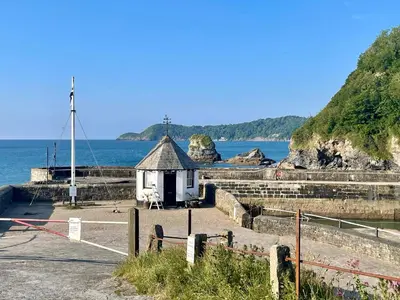 a small building next to a body of water at Neptunes Rest in St Austell