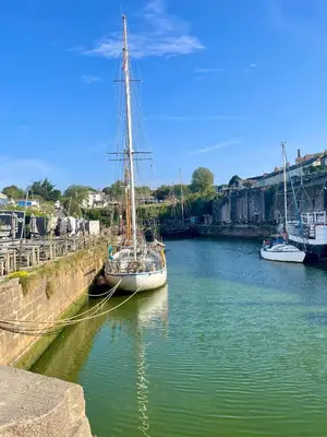 a sail boat docked in a river with other boats at Neptunes Rest in St Austell