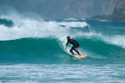 a man riding a wave on a surfboard in the ocean at The Old Wagon House in Saint Clether