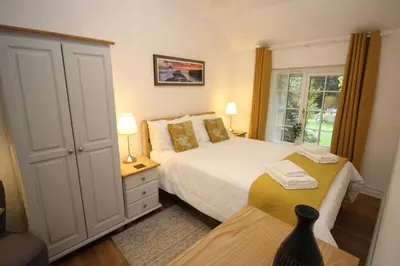 a small bedroom with two beds and a window at Almond Tree Cottage in Lanteglos