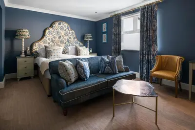 a blue bedroom with a bed and a blue couch at The Headland Hotel and Spa in Newquay