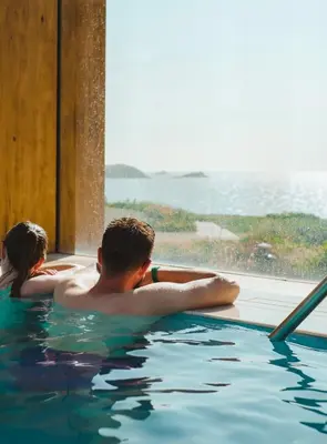 a man and a little girl in a swimming pool at The Headland Hotel and Spa in Newquay