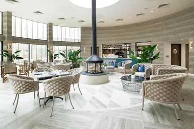 a lobby with tables and chairs and a fireplace at The Headland Hotel and Spa in Newquay