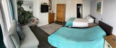 a hotel room with two beds and a couch at Sawyers Bed and Breakfast in Looe