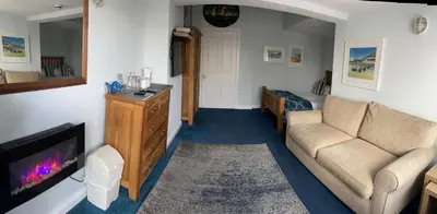 a living room with a couch and a tv at Sawyers Bed and Breakfast in Looe