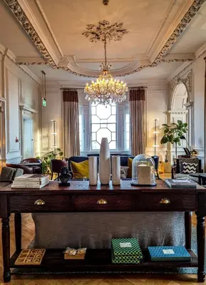 a large living room with a large wooden table at Fowey Hall Hotel in Fowey