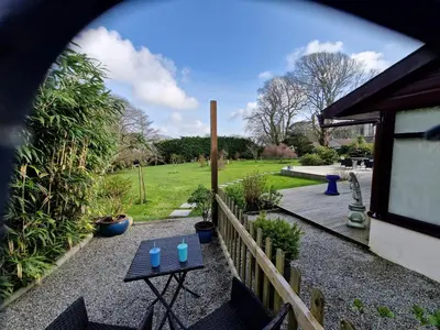 a view of a garden with a table and a fence at The Cedars in Redruth