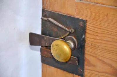 a wooden door with a gold door knob on it at Sea Haze Charlestown in St Austell